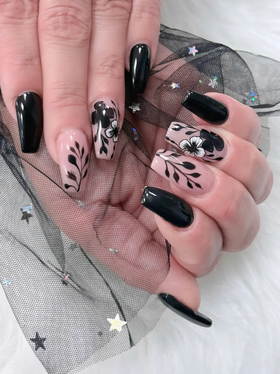 Black coffin nails with soft nude floral detailing by V Nails Lacombe