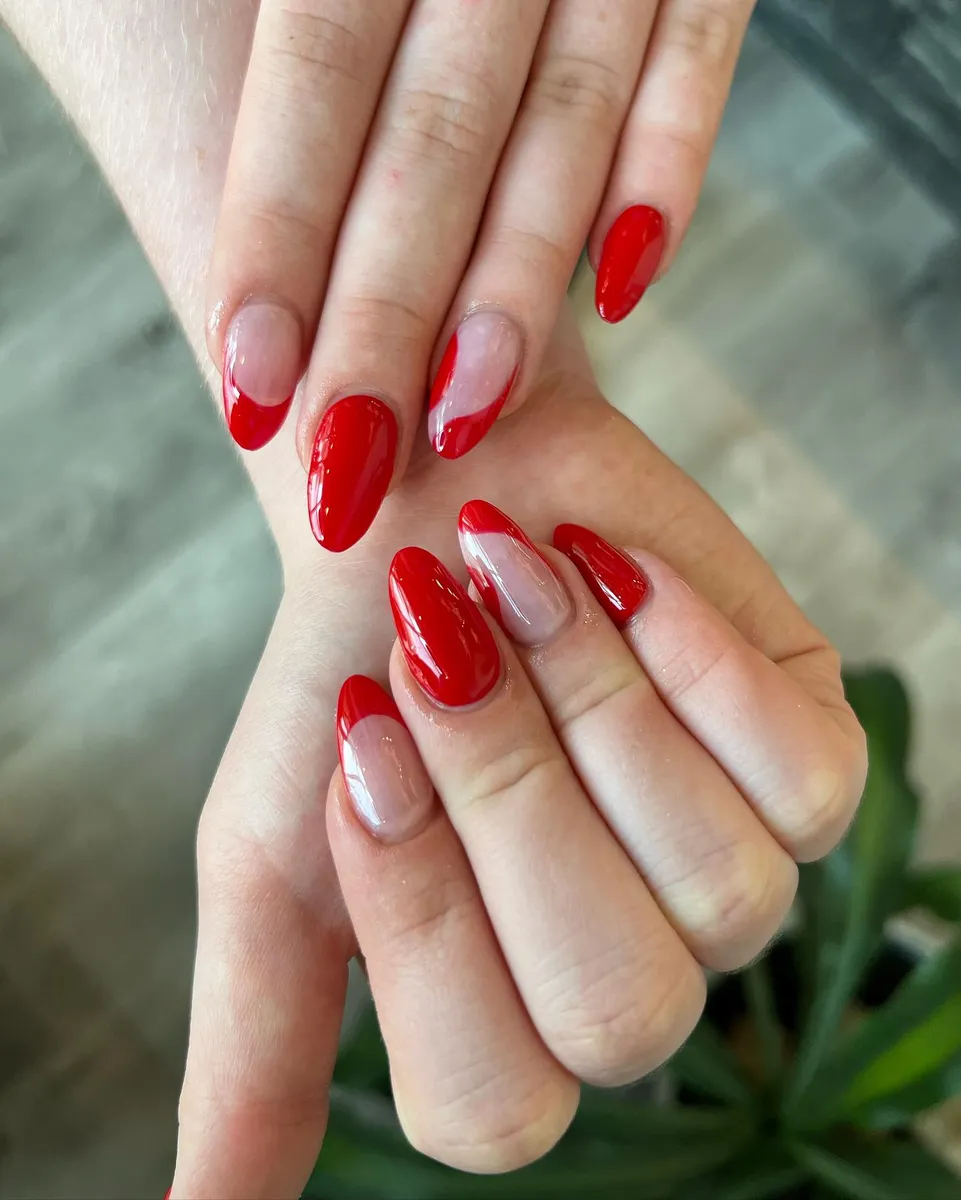 Glossy red nails with nude half-moon details by V Nails Lacombe