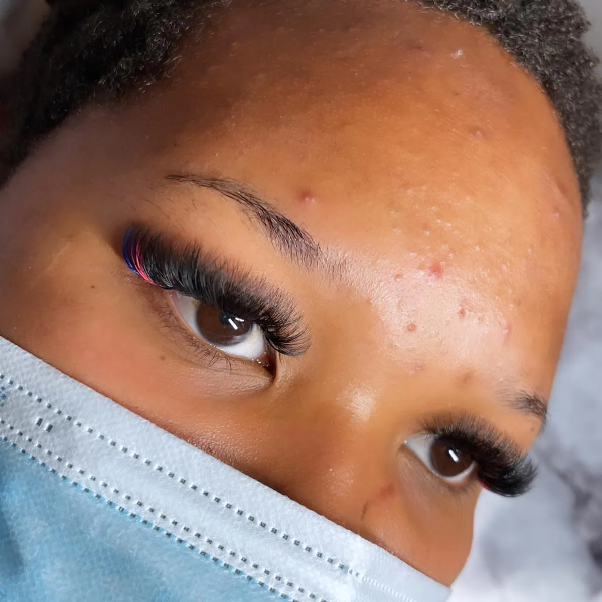 Full volume lash extensions with crimson corner accents by V Nails Lacombe